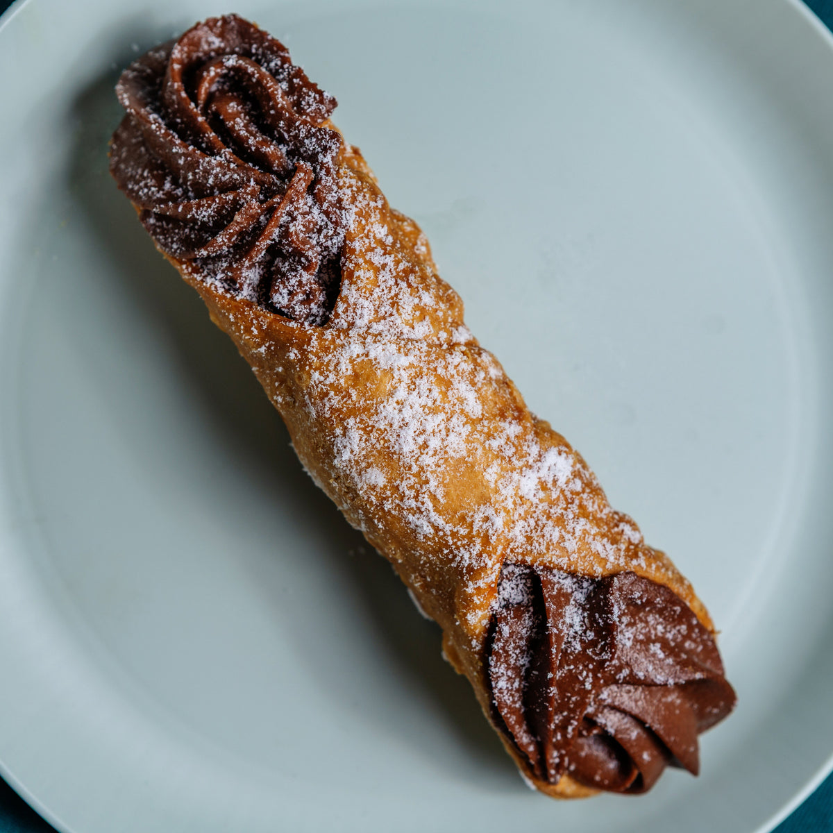 Chocolate cannolo with piped chocolate cream, dusted with icing sugar, Milano Cakes Wollongong