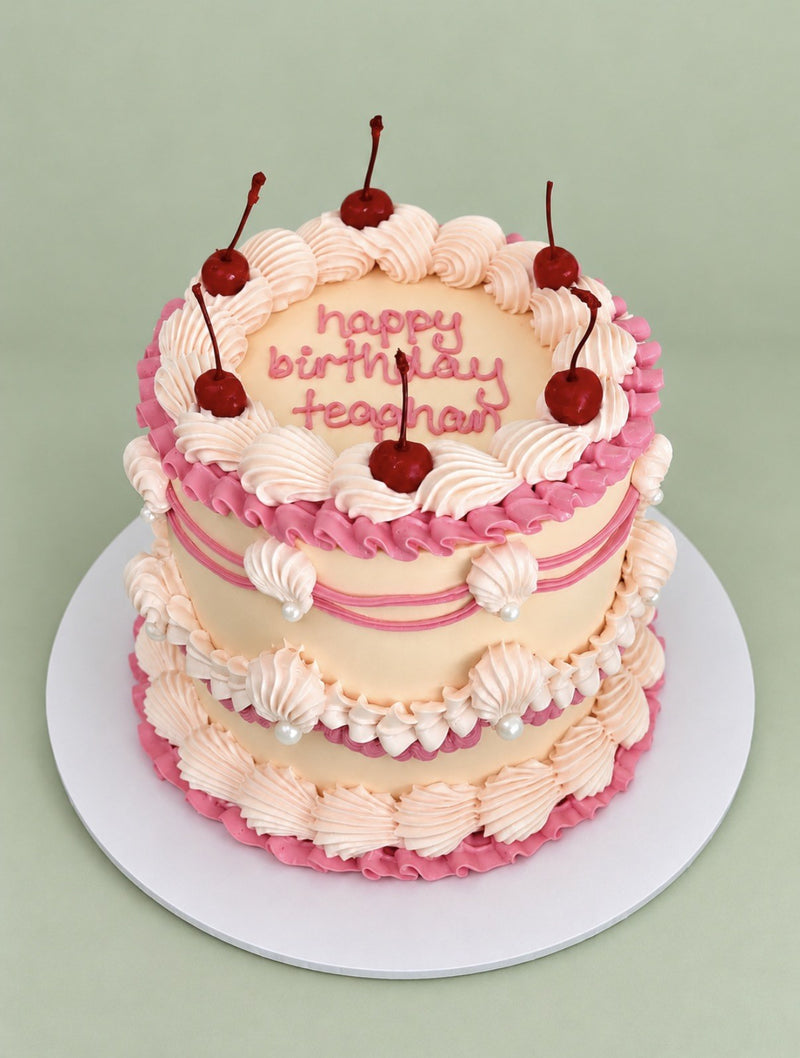 Vintage piped birthday cake with cherries